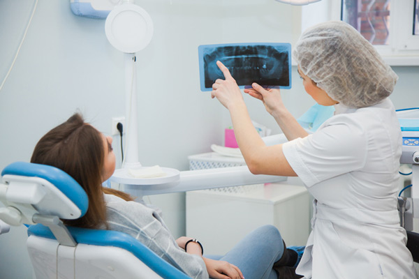 A woman reviewing her xray with a dentist at Aesthetic Periodontal & Implant Specialists