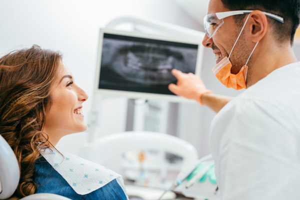 Periodontist explaining an x-ray to a female patient.