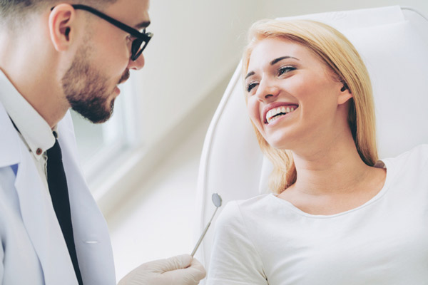 Person smiling while an oral surgeon talks.