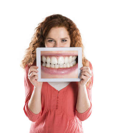 Red head woman holding up picture of teeth Red head woman holding up picture of teeth