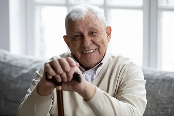 A portrait of a senior man smiling, showing off his healthy teeth.